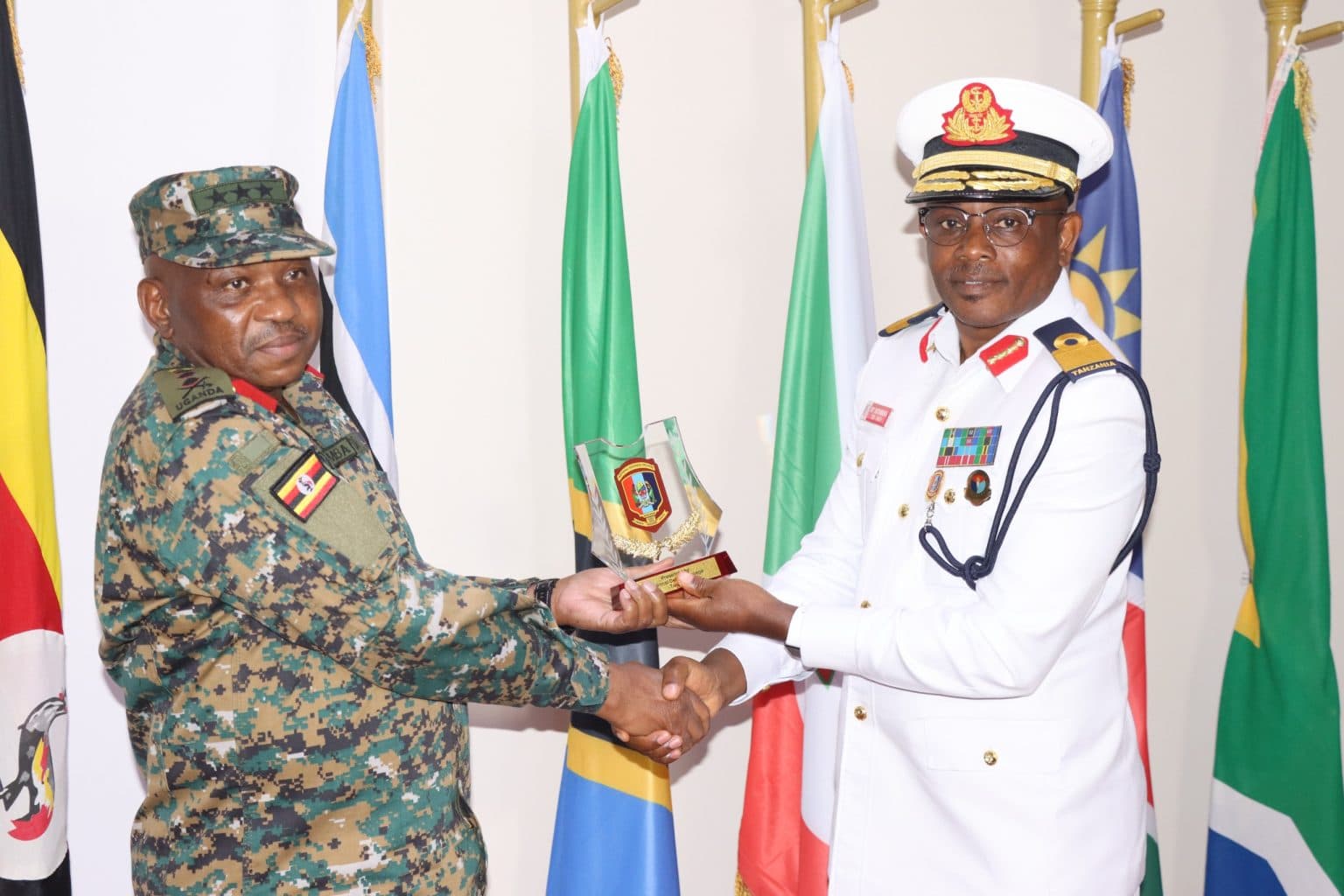 UPDF Chief of Joint Staff Lt Gen Jack Bakasumba receiving a souvenir from Tanzanian Head of Delegation Commodore Baganchwera Traseas Rutambuka at DIS HQ.