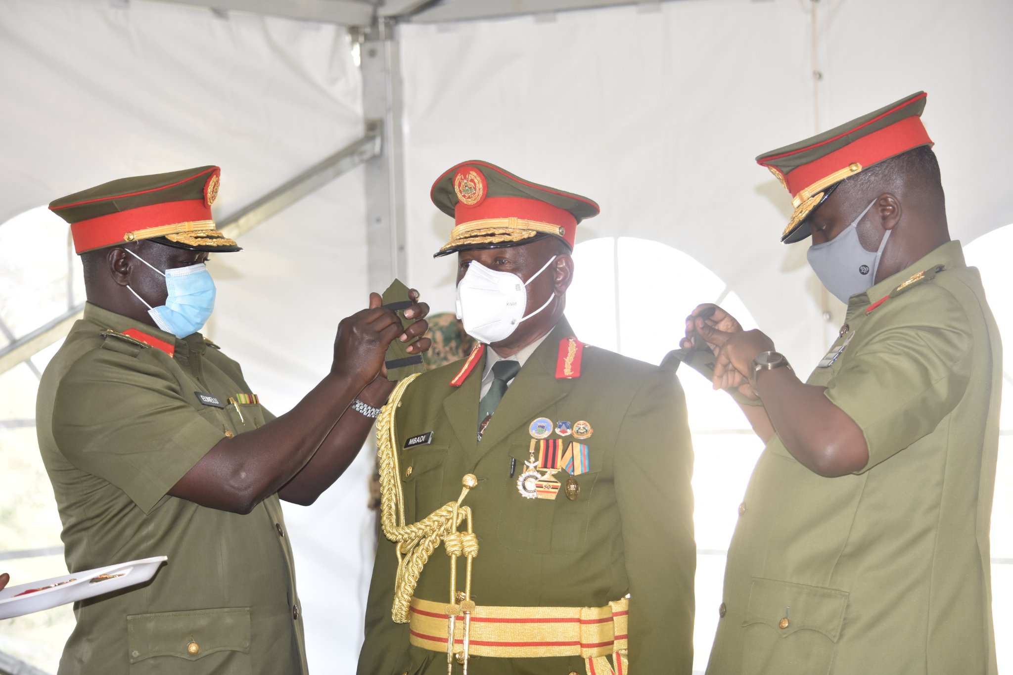 Gen Mbadi is decorated by his colleagues Gen Muhoozi and Lt Gen Elwelu. DPU Photos