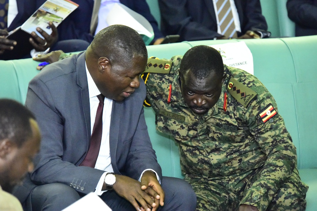 The Deputy Chief of Defence Forces, Gen Peter Elwelu (R) consults State minister for Defence, Oboth Oboth during plenary