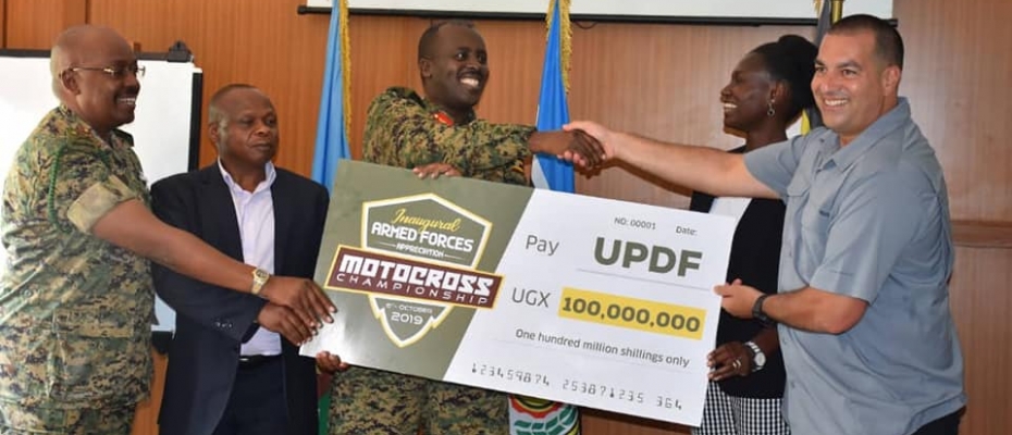 CDF Muhoozi (C) receives the Sh100M dummy cheque from UMC President Dusman Okee. DPU photo